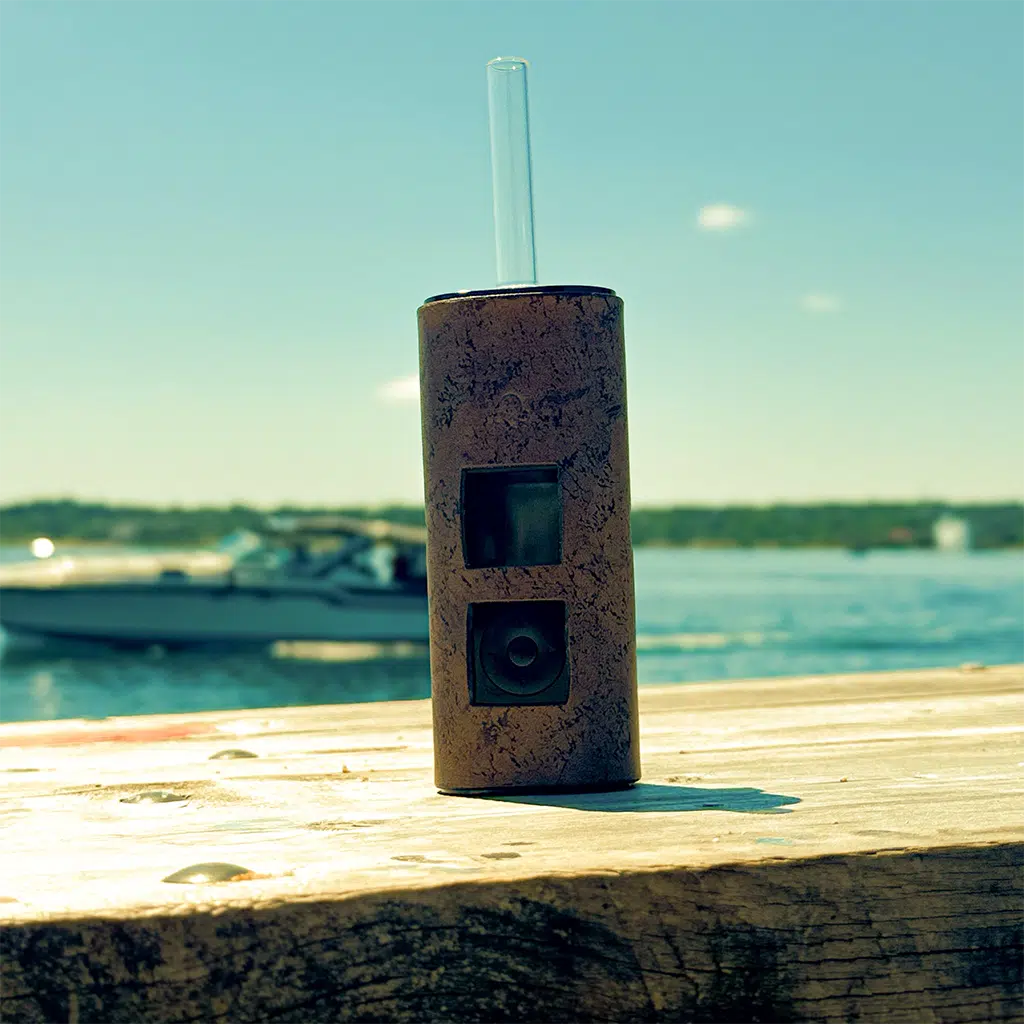 LabetKomp leather Solo 3 sleeve in Sun-Kissed Sahara in front of a passing boat casting shade from the sun behind